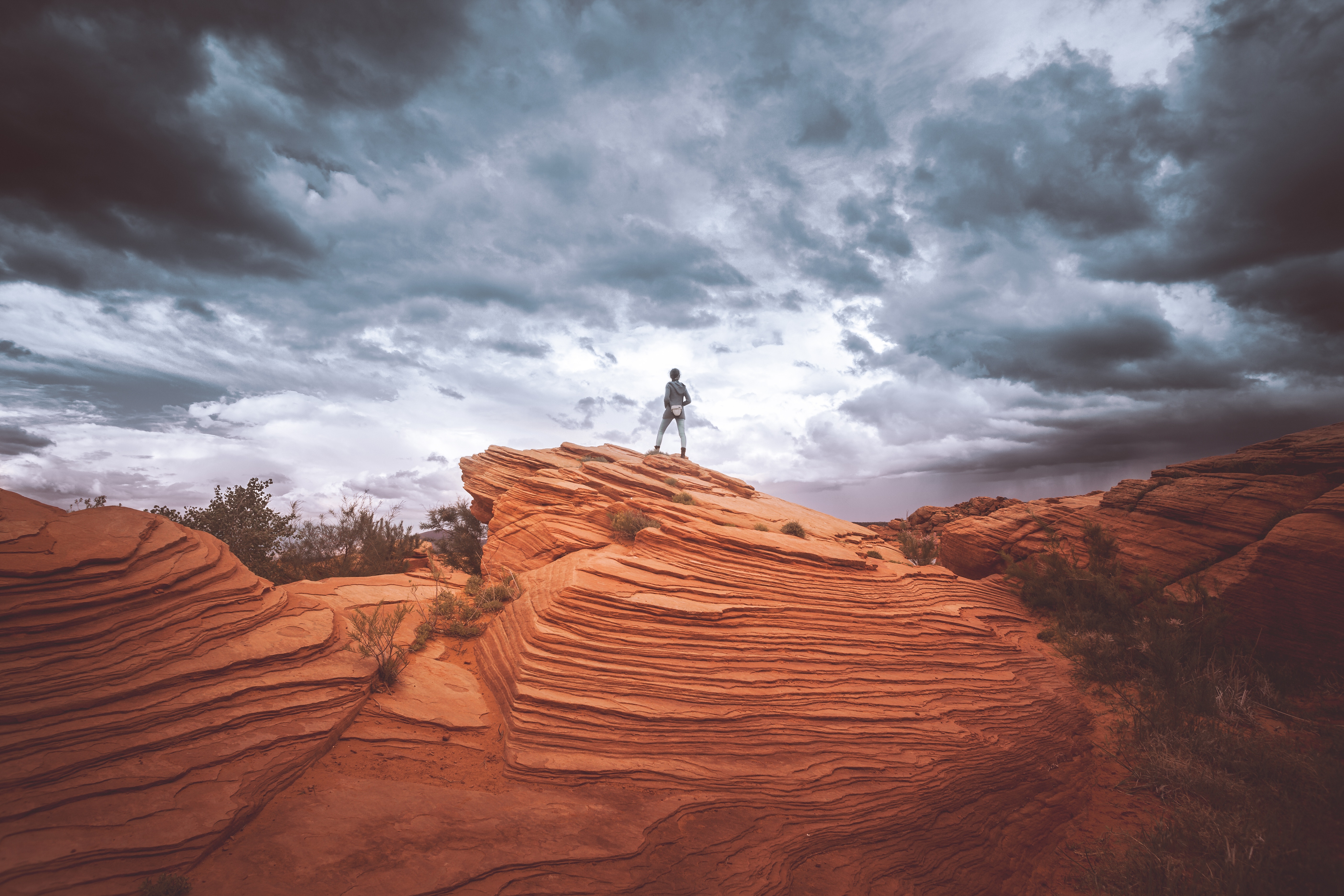 person standing on rock formation, photo by Cédric Frixon